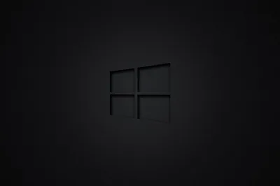 The four-pane mark cut in dark grey at the centre of a soft black gradient, the outline only just separating from the background.