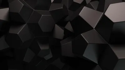 Dozens of matte black cubes pile up at odd angles, edges lit softly so the shapes read against each other.