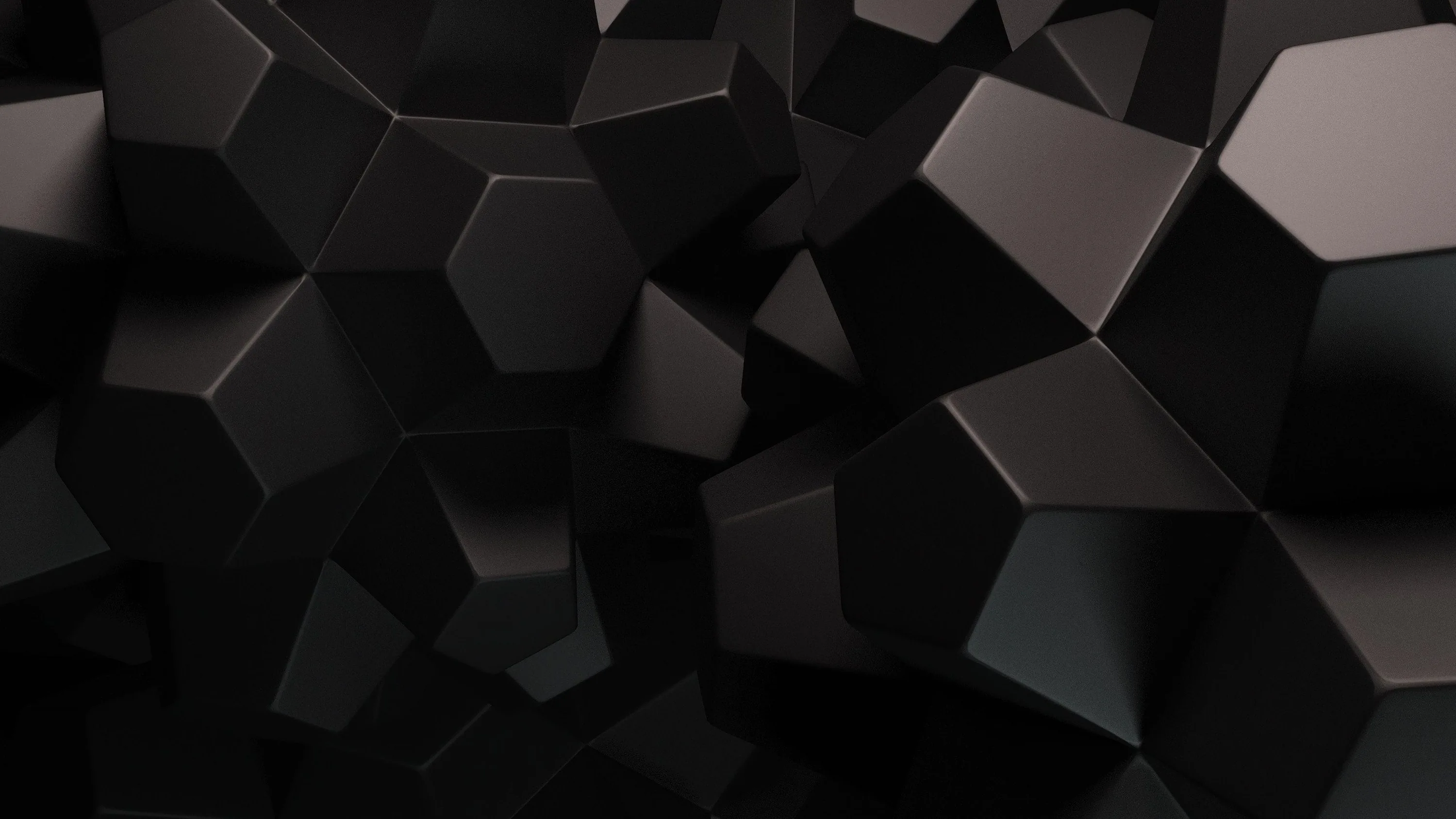 Dozens of matte black cubes pile up at odd angles, edges lit softly so the shapes read against each other.