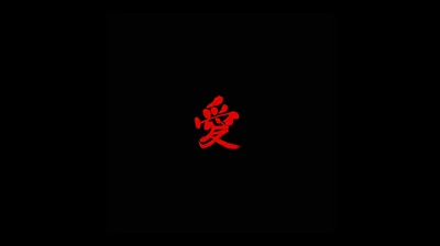 The character 愛 is brushed small in deep red at the middle of an otherwise completely black frame.