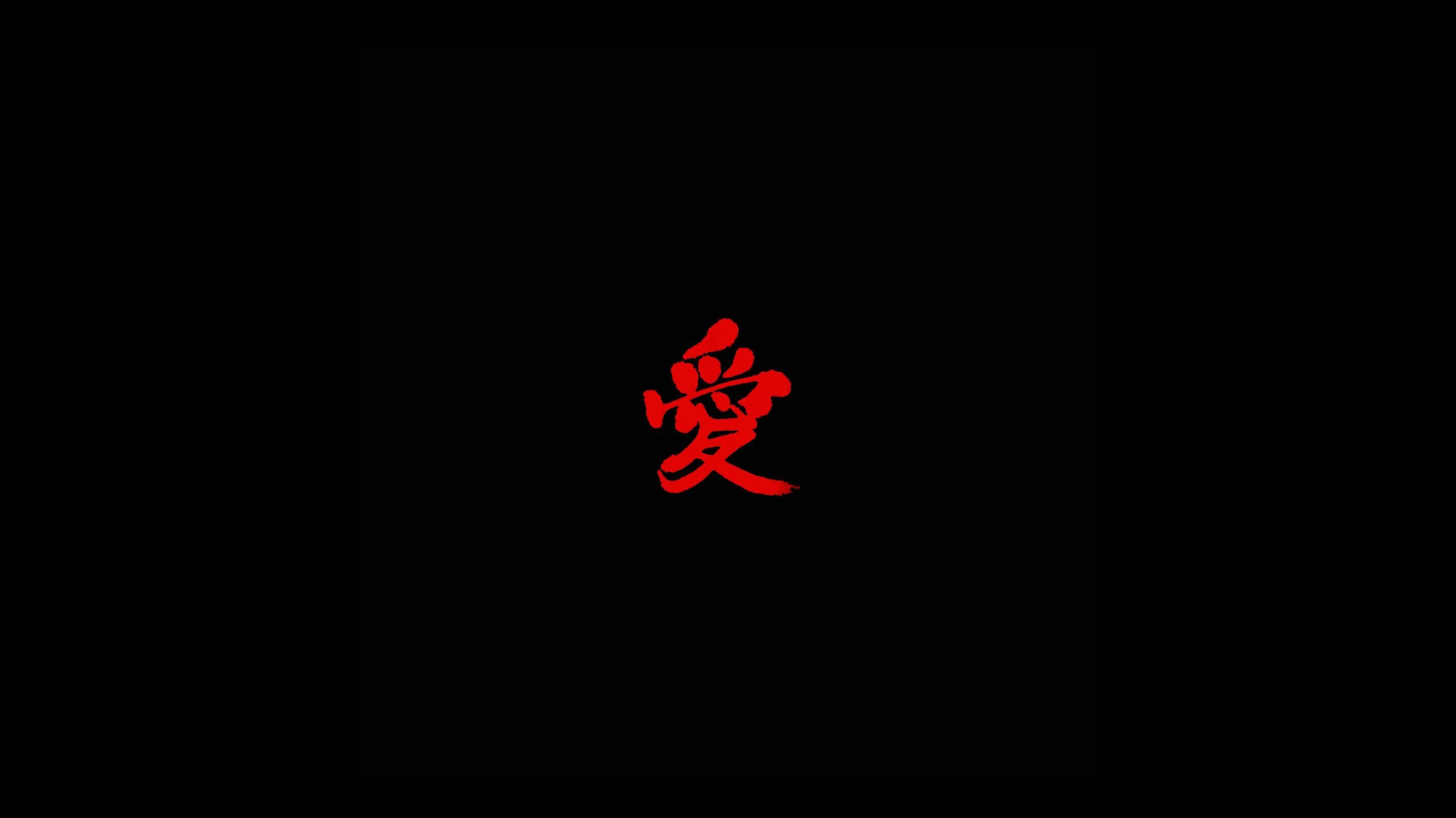 The character 愛 is brushed small in deep red at the middle of an otherwise completely black frame.