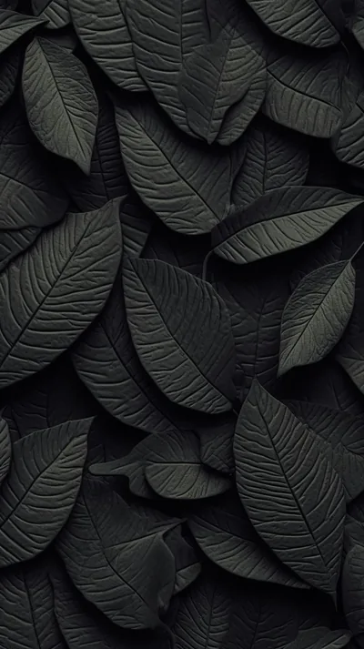 Overlapping leaves moulded in matte black fill the frame, side lighting picking out every vein and raised edge.