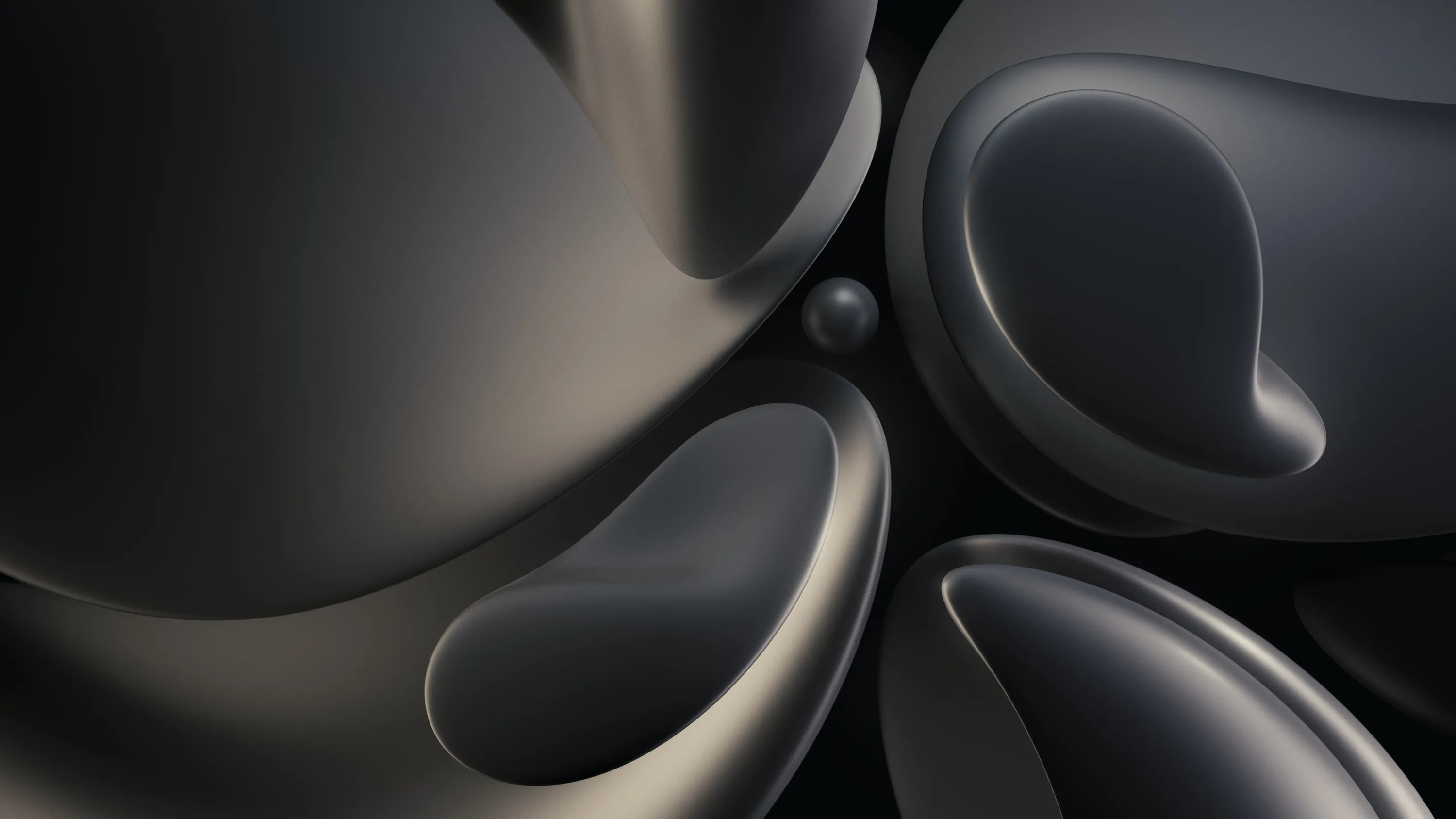 Rounded graphite forms press against each other with soft hollows scooped out of them, a small sphere resting in the gap at the centre.
