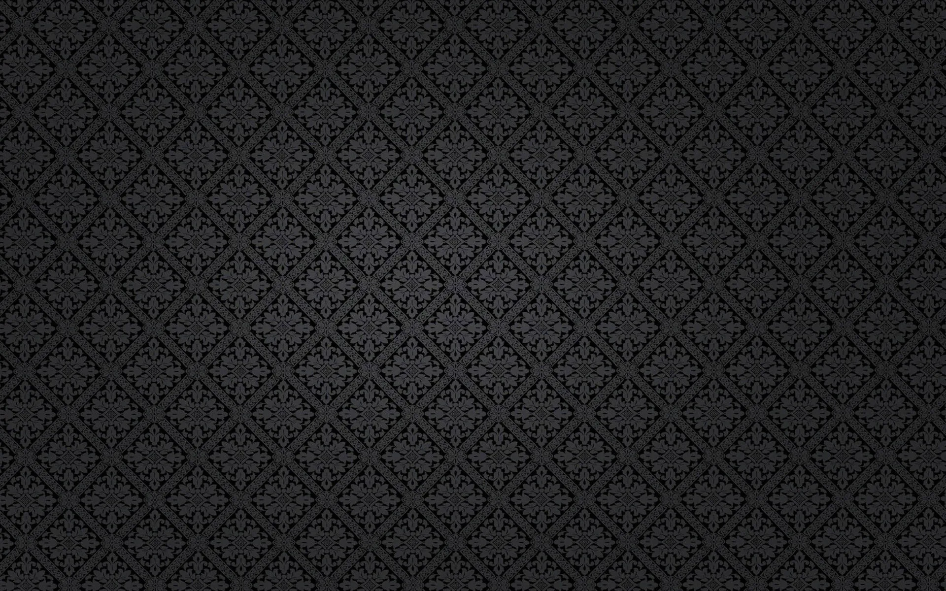 A small symmetrical damask motif repeats in tidy rows across slate grey, lit gently from the centre with the outer edges left in shadow.