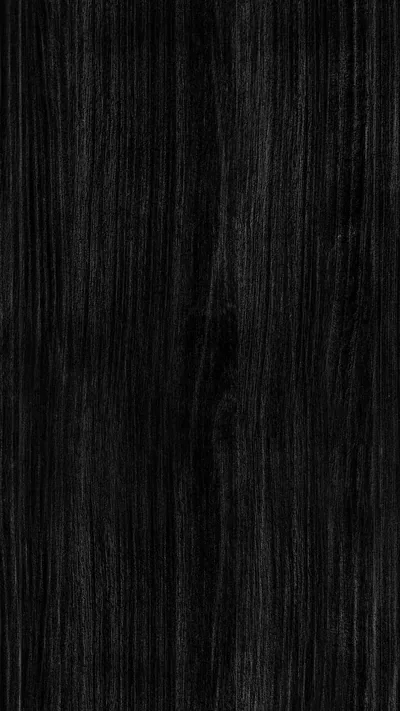 Long straight grain lines run top to bottom through near-black wood, a few pale streaks in the centre where the light catches the raised fibres.