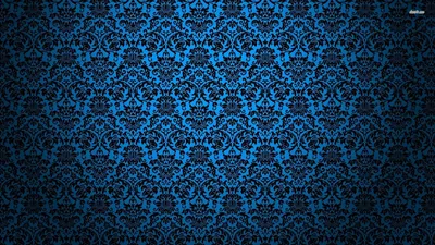 A repeating damask motif printed in bright blue over black, evenly tiled across the whole wall with the corners dropping into shadow.