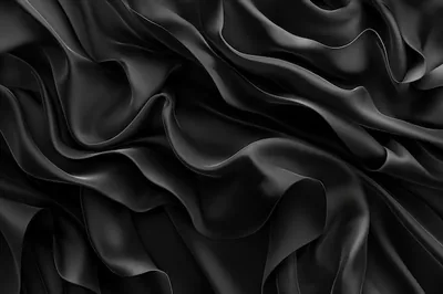 Matte fabric pleats ripple across the frame like dark water, grazing light from the upper left picking out each ruffled crest against deep shadow.