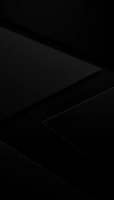 Two large dark surfaces cross the frame at an angle, a single hairline of grey tracing the fold where they meet.