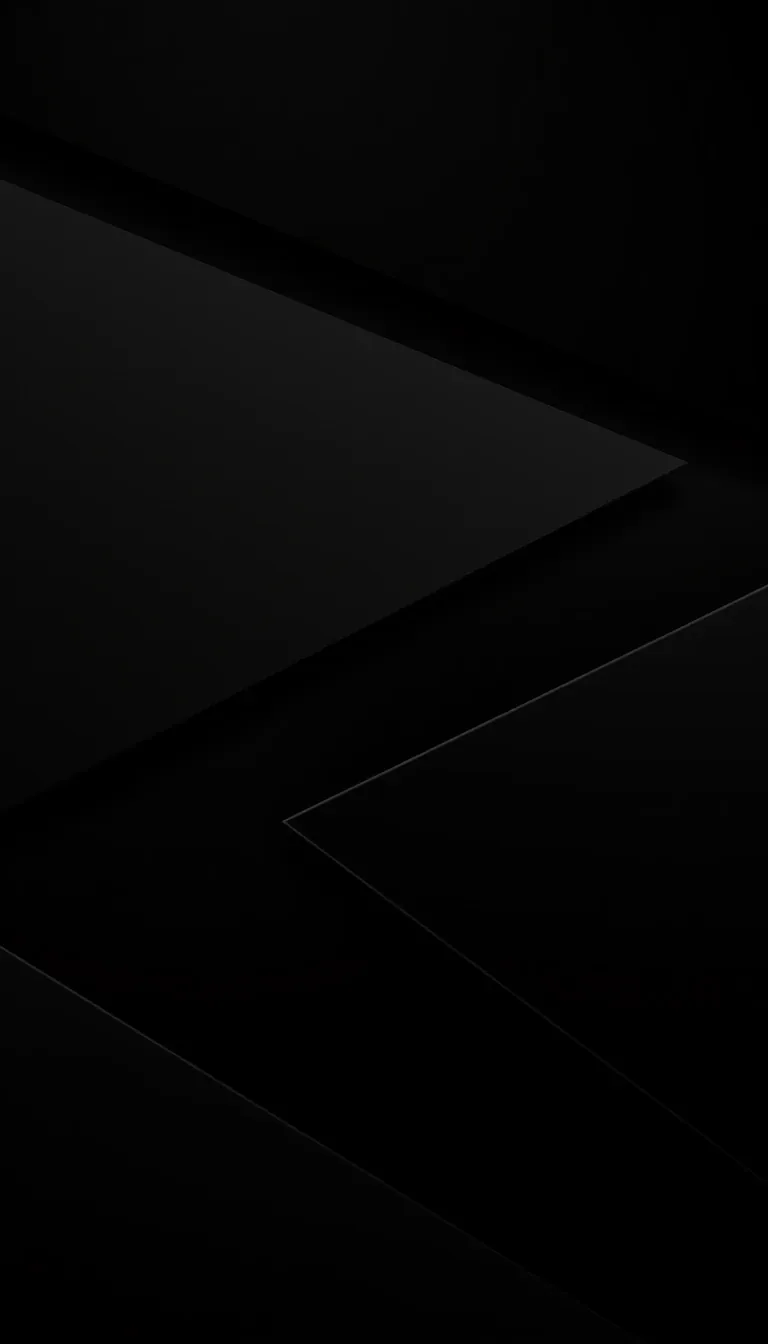 Two large dark surfaces cross the frame at an angle, a single hairline of grey tracing the fold where they meet.