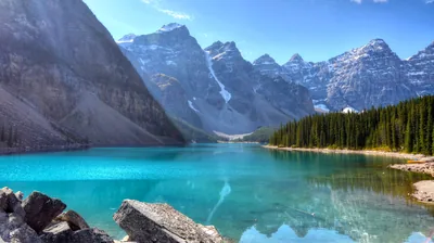Milky turquoise fills the whole lower half beneath a wall of grey spires, and that flat expanse of colour keeps app labels easy to read.