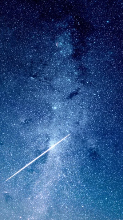 A meteor streaks diagonally through a dense blue star field below the Milky Way, cutting the lower half while the top stays quieter for a clock.