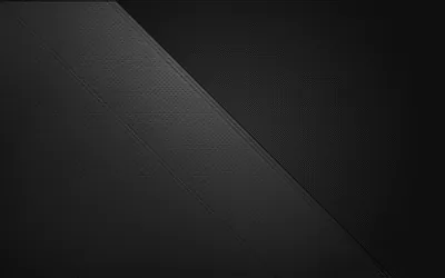 A clean diagonal divides two shades of near-black, both surfaces carrying a fine leather-like grain.