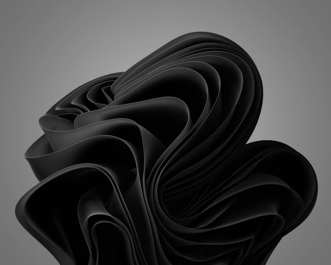 The Windows 11 bloom rendered in black folded ribbons on a plain grey field, the flower leaning left so the right third stays clear for icons.