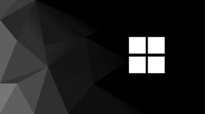 The four-pane mark sits bright white on the right while faceted grey polygons crowd in from the left edge, the middle held in flat black.