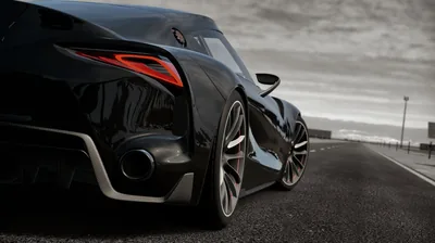 Shot from the tarmac beside the rear wheel, the concept's slotted tail lamp and twin exhausts run away toward a flat grey sky over an empty runway.