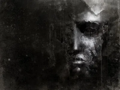 A face surfaces out of cracked paint and soot, one cheek catching a pale glow while the rest sinks back into the mottled dark.