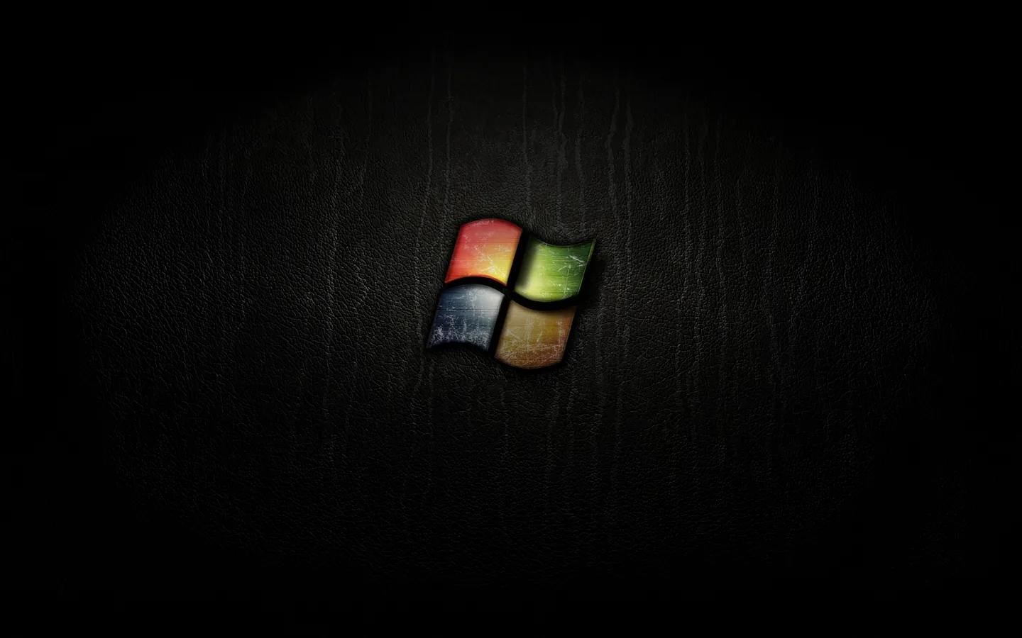 The four-colour window flag sits small at the centre of a scratched dark wood surface.