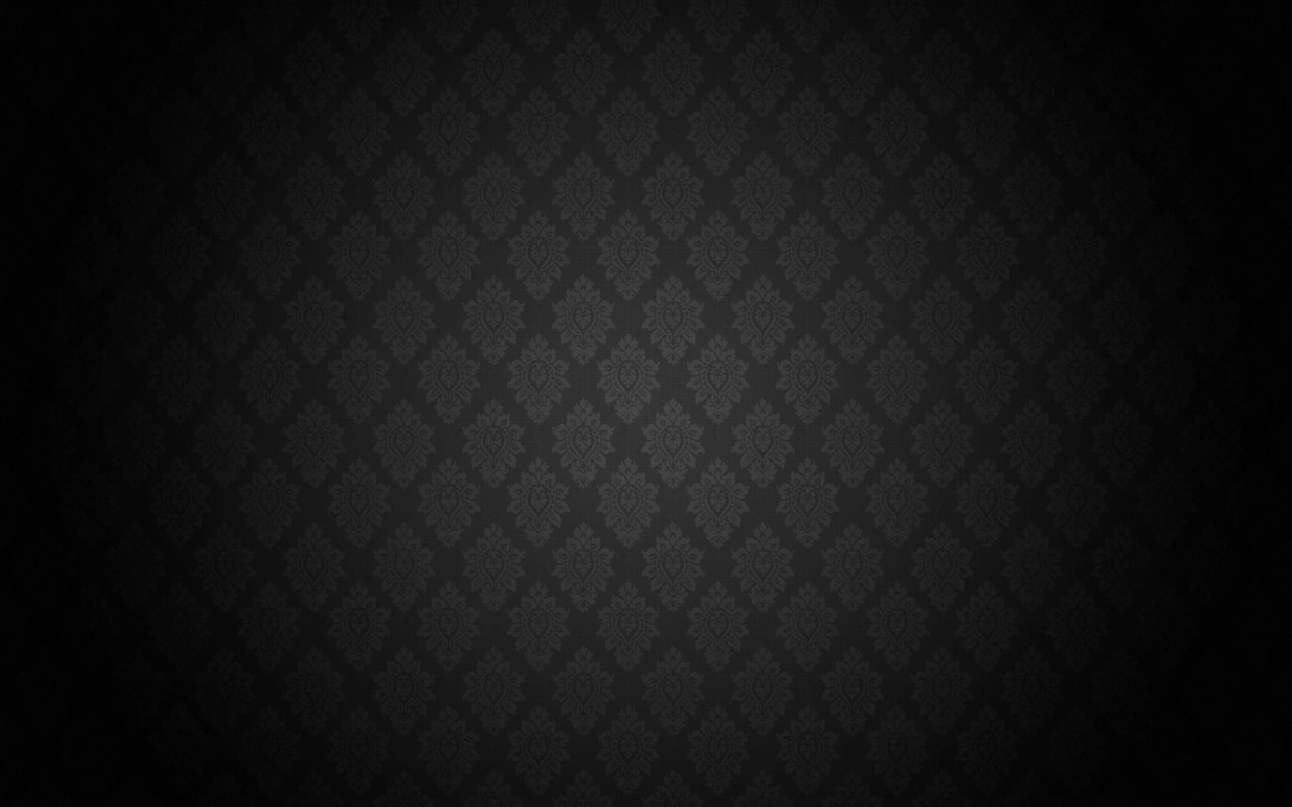 A quilted diamond lattice with a small flourish in each cell glows through the centre of the frame while the border drops to solid black.