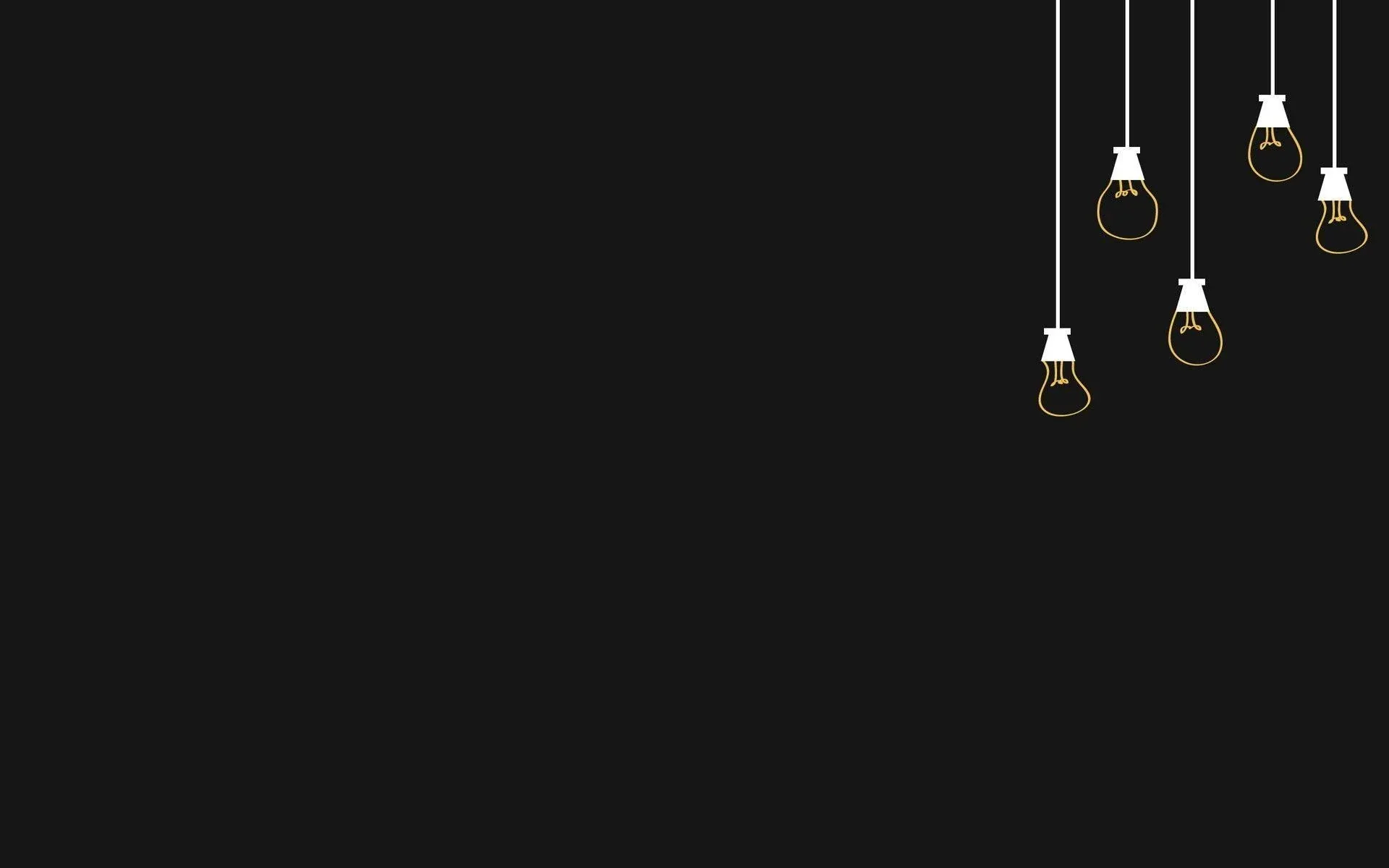 Five filament bulbs drop on thin white cords from the top right corner, warm and small against a wide sweep of empty dark grey.
