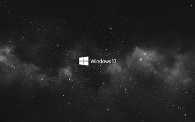 The small white Windows 10 mark and wordmark sit centred in a grey starfield, clouds of dust spreading left and right.