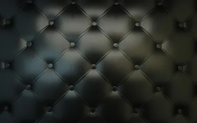 Deep-buttoned black leather diamonds fill the frame, a cool light from the upper left picking out each ridge before the lower corners go dark.