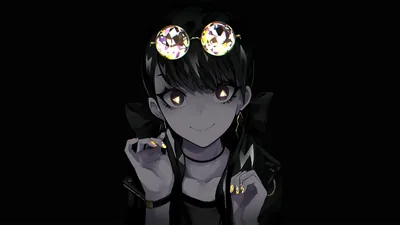 A dark-haired girl smiles against solid black, twin jewelled clips and her gold rings the only points of light in the frame.