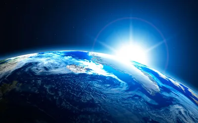 The sun breaks over the planet's horizon in a sharp star flare, cloud swirls below tinted deep blue, with the flare kept to the upper right.
