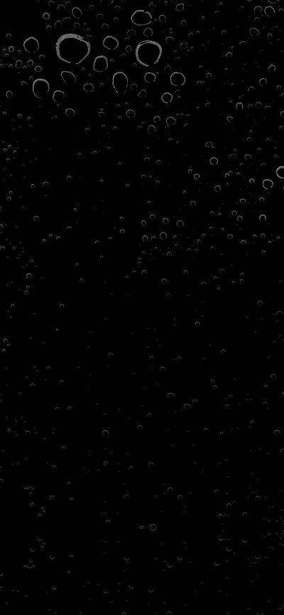 Clusters of round bubbles gather at the top of the frame and thin out as they fall, the rest of the screen left black.