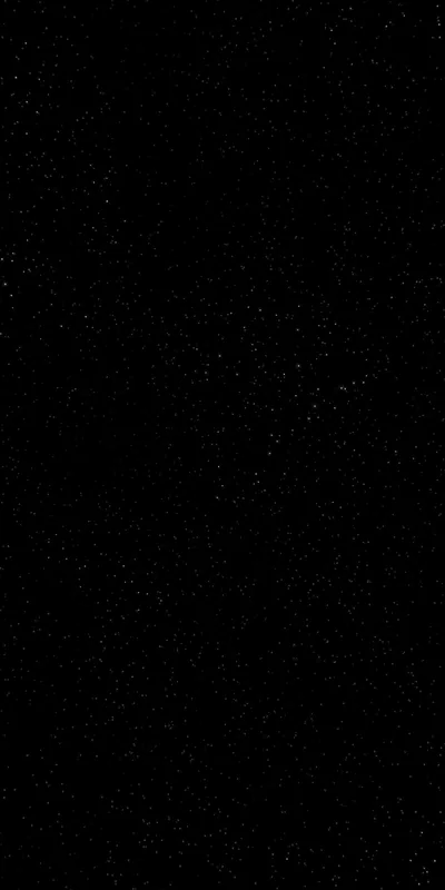 Almost the entire frame is unbroken black, with tiny star specks surfacing only when the screen is turned up.