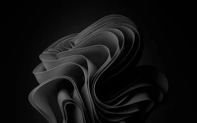 Sheets of black material fold over one another into the Windows 11 bloom, every crease traced by a thin white highlight on an unlit ground.