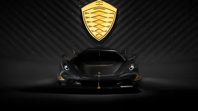 The Jesko faces the camera dead centre with the gold shield emblem hanging above it, gold trim on the splitter and mirrors the only warm notes in a black room.